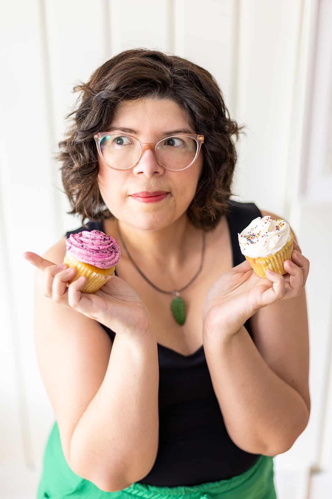 Rita holding 2 cupcakes